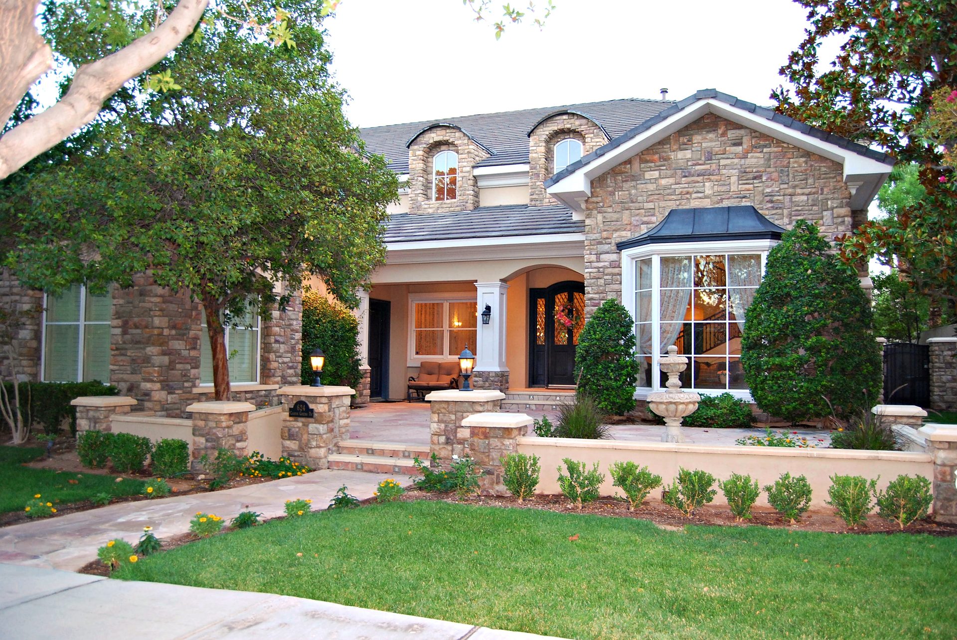 Twilight view of the stone facade and landscaped front courtyard at 624 Canyon Greens